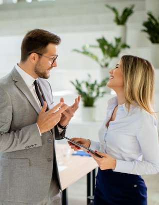 Two colleagues talking over a tablet in an office