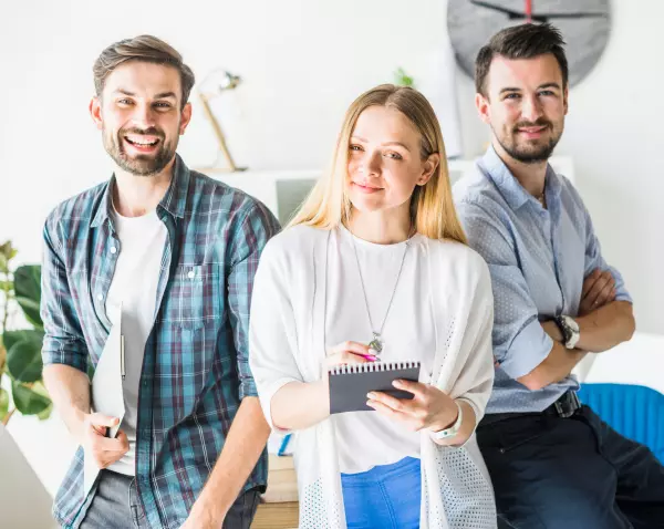 Three colleagues standing together in an office